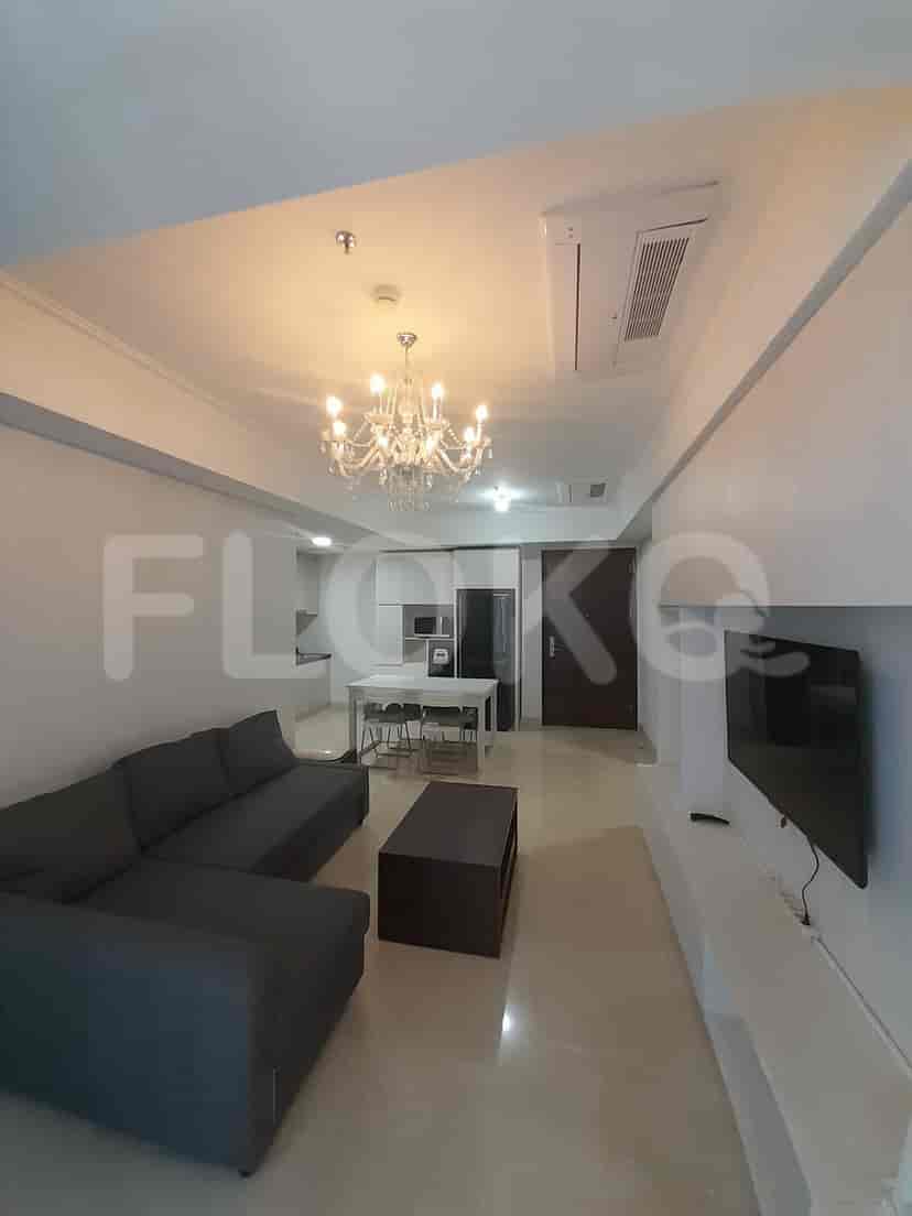 Spacious living room with L-shaped sofa, dining area, and chandelier.