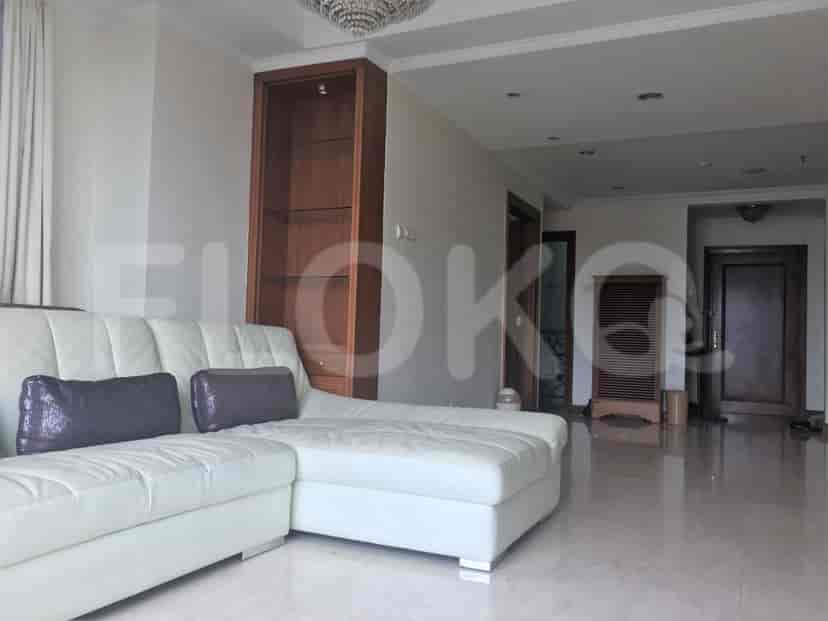 Living room with a cream sofa, chandelier, and access to other rooms.