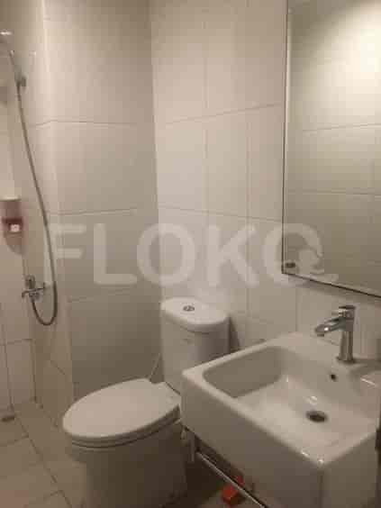 A clean bathroom with a toilet, sink, and shower area.