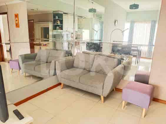 Living room featuring two grey sofas, mirrors, and a TV.
