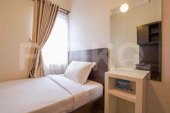 Small bedroom with single bed, curtains, and mirror.