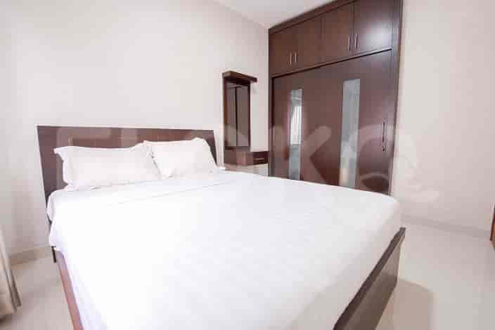 Bedroom with dark wooden bed, built-in closet, and mirror.