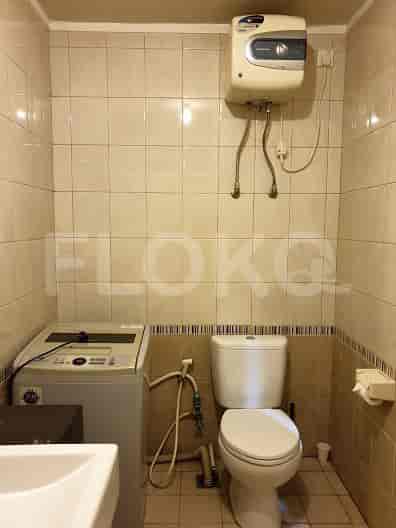 A bathroom with a toilet, sink, and washing machine.