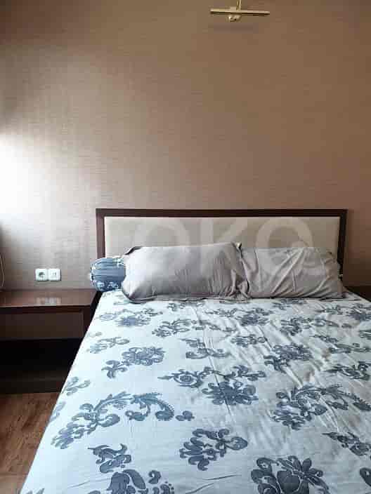 A bedroom with a bed and a bedside table.