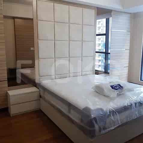 Bedroom with a king-size bed, mirror and wooden closet.