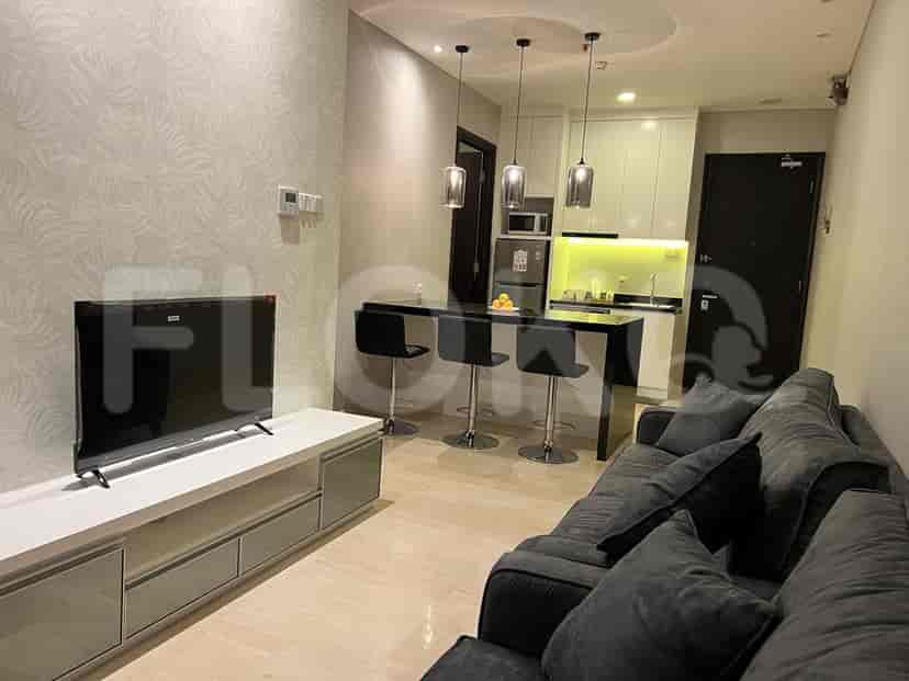 Modern living room with a grey sofa, TV, and open kitchen with a breakfast bar.