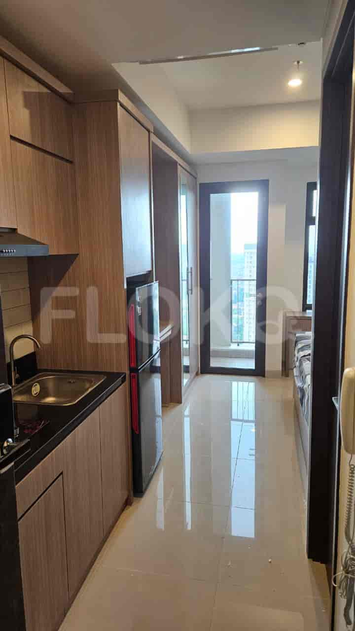 Small kitchen with built-in cabinets, a fridge, and access to the living space.
