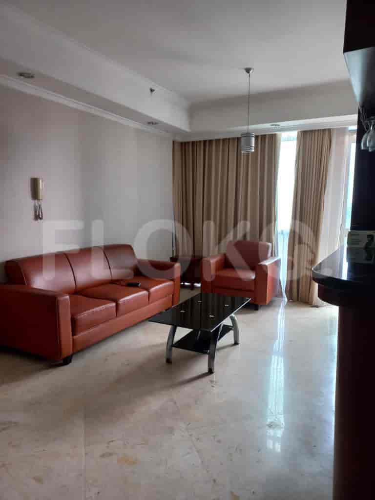 Living room with brown sofa, coffee table, and two armchairs.