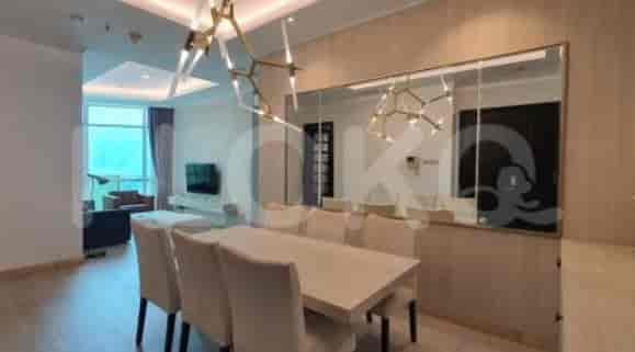 A dining area with a large table, chairs, and a decorative mirror.