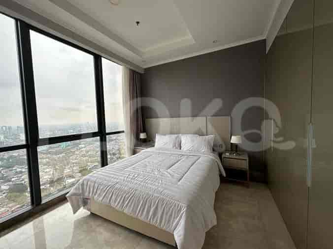 Bedroom with a large window, bed, and city skyline.
