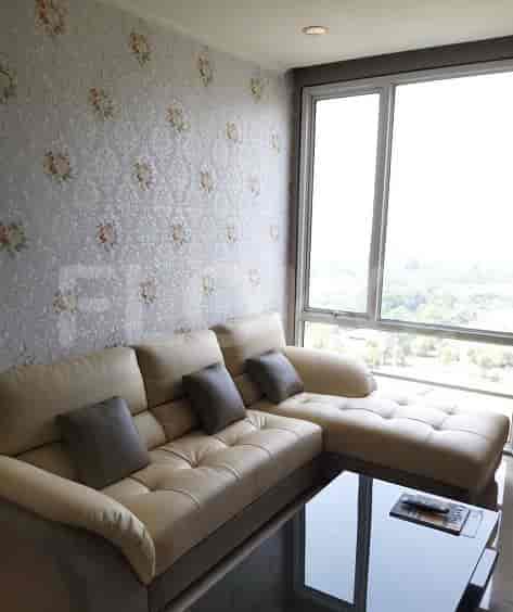 Living room with beige sofa and large windows.