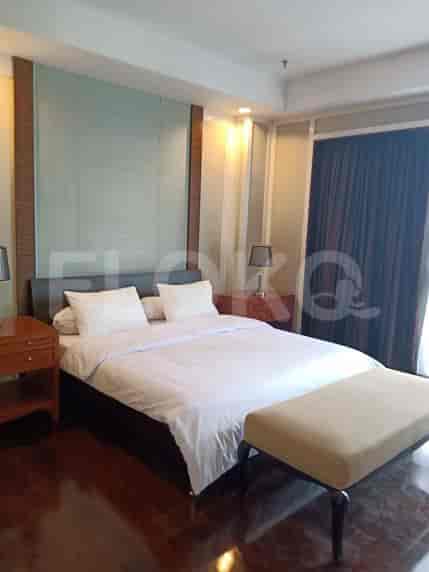 Bedroom with a king-sized bed, nightstands, and a bench.
