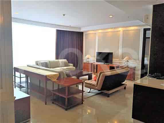 Spacious living room with an L-shaped sofa, TV, and large window.