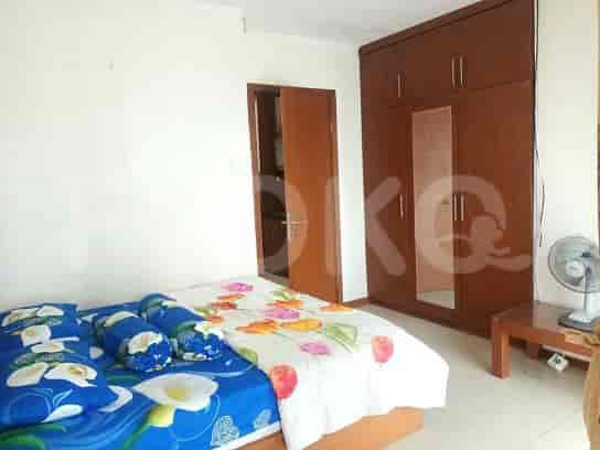A bedroom with a double bed, a wardrobe, and a fan.