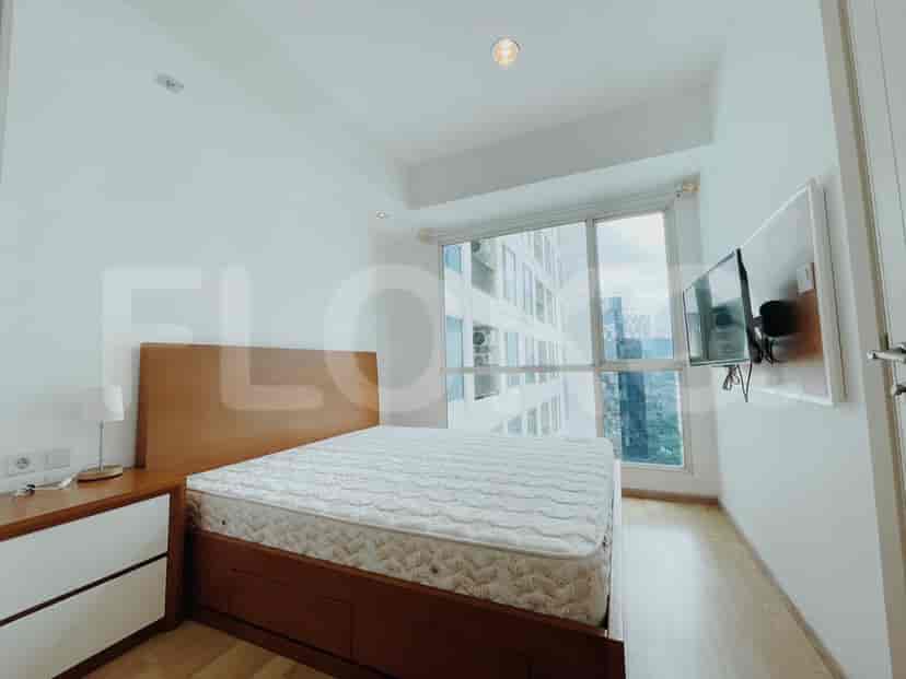 Kamar tidur dengan tempat tidur, TV, dan jendela besar.