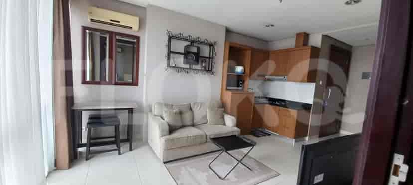 A compact apartment showcasing a living area with a kitchenette and dining space.