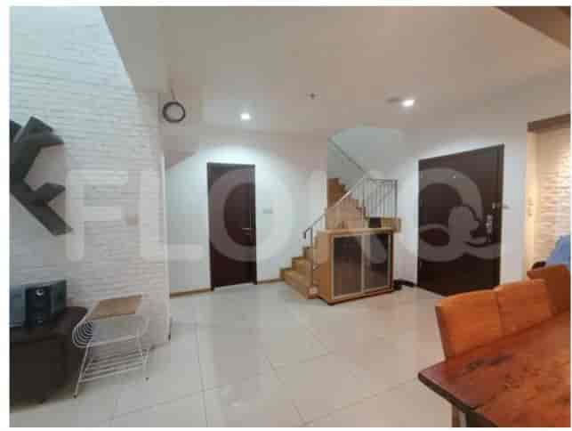 An expansive living area with a staircase leading to an upper floor, showcasing a minimalist aesthetic.