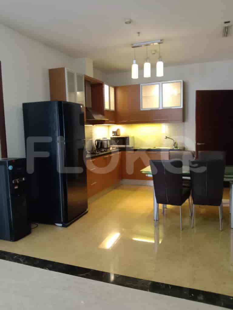 A kitchen with black fridge and wooden cabinets.