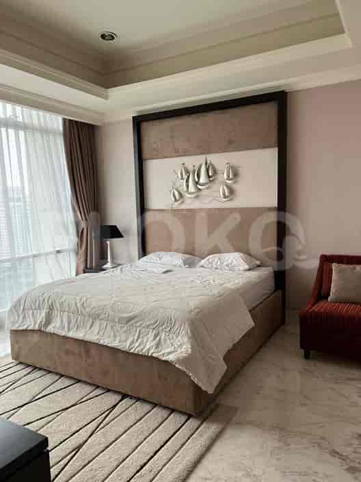 A master bedroom with a large bed, a feature headboard, and artwork.