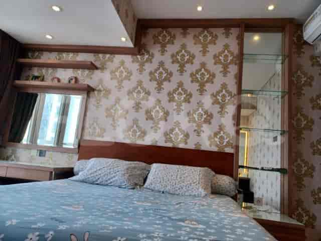 Bedroom featuring a double bed, wallpaper, and wooden furniture.