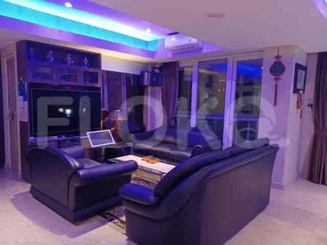 Living room with a black leather sofa, TV, and a door leading to the balcony.
