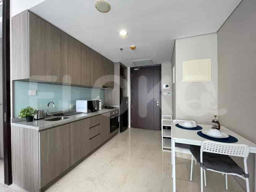 Sleek kitchen with wooden cabinets, and a small dining set.
