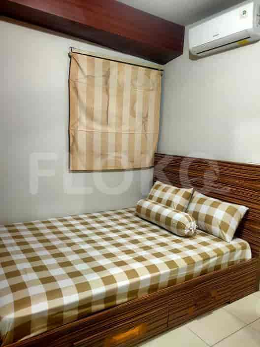 Kamar tidur dengan tempat tidur, sprei kotak-kotak, dan headboard kayu, bersama dengan jendela dan gorden.