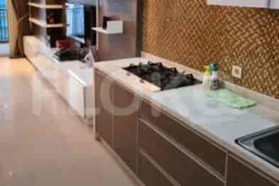 A modern kitchen with a gas stove, white countertops, and brown cabinets.
