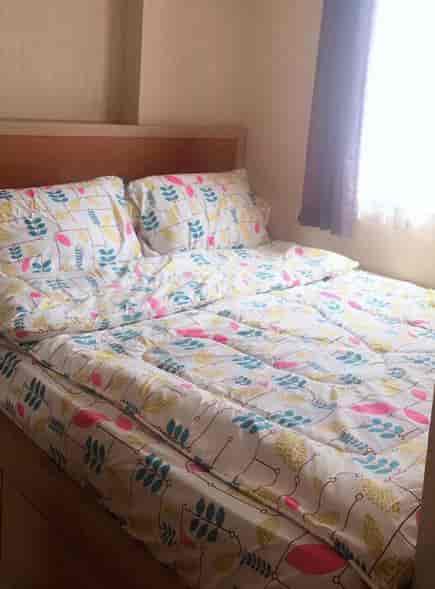 Kamar tidur yang nyaman dengan tempat tidur dan sprei bermotif.