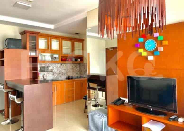 Kitchen area with wooden cabinets, a breakfast bar, and a colorful wall clock.