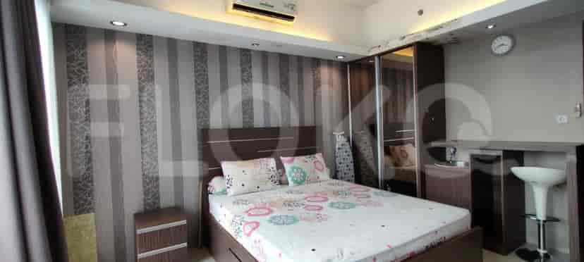 Bedroom with bed, wardrobe, and a small kitchen area.