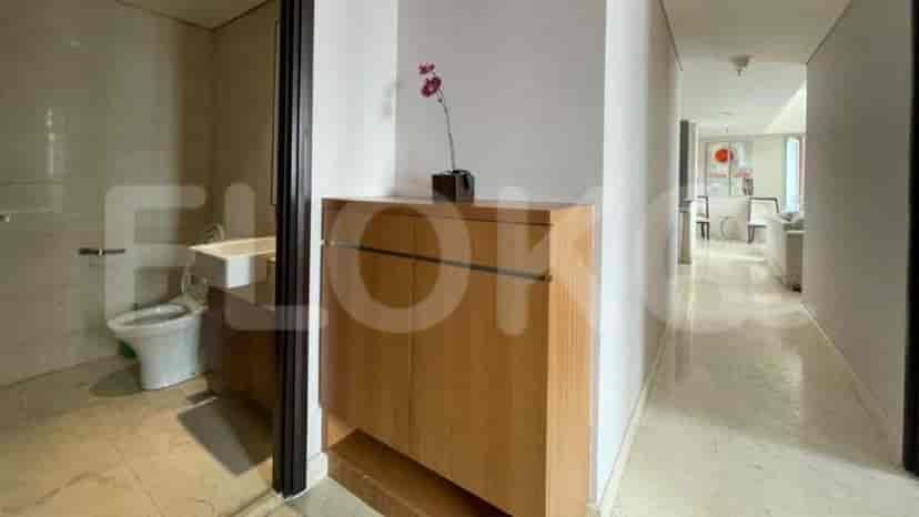 A hallway with a wooden storage cabinet and access to the bathroom.