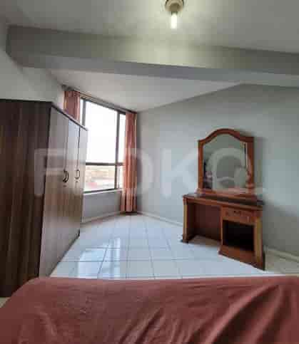 Bedroom featuring a bed, closet, vanity with mirror, and a large window.