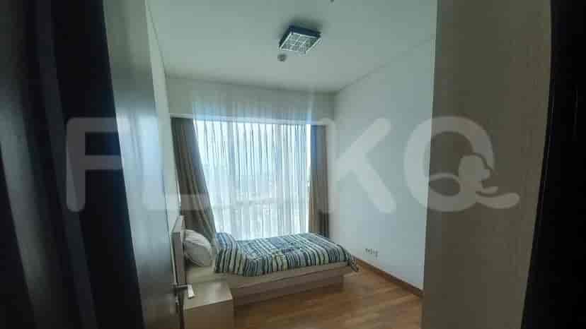 Bedroom with a bed and curtained window.