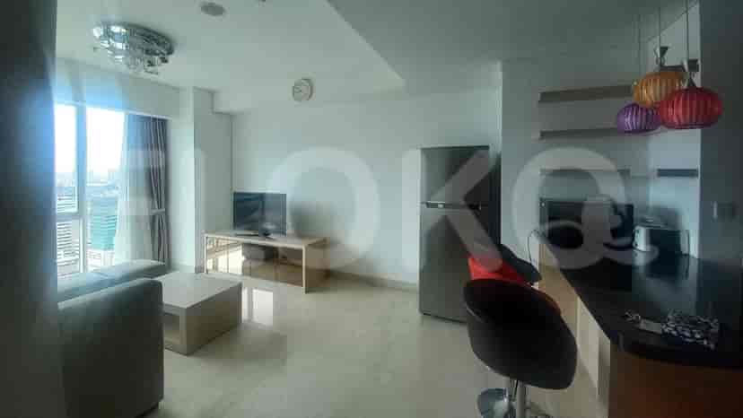 Spacious living room with sofa, TV, and city view.