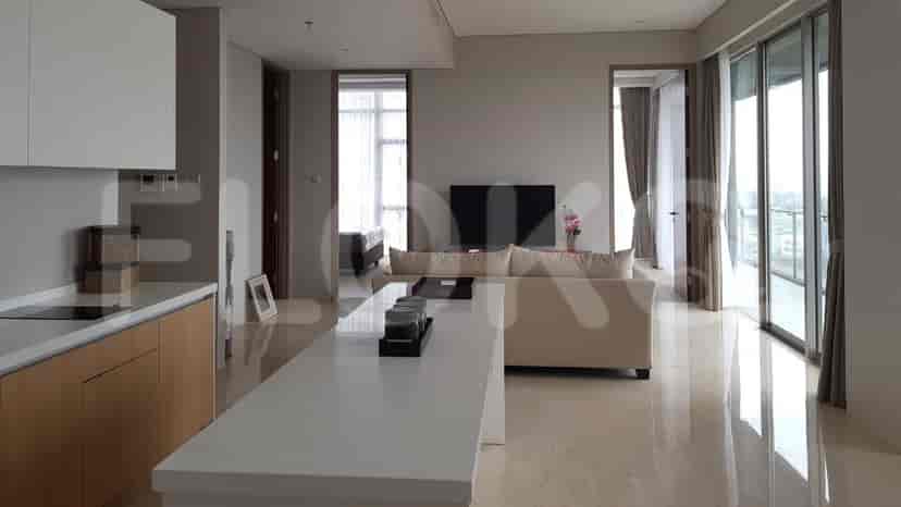 An open-concept living area with a kitchen island, sofa, and balcony access.