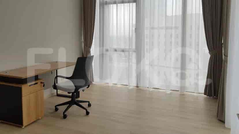 A home office setup with a desk, chair, and large window.