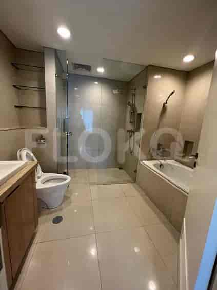 A modern bathroom with a glass-enclosed shower, bathtub, and toilet.