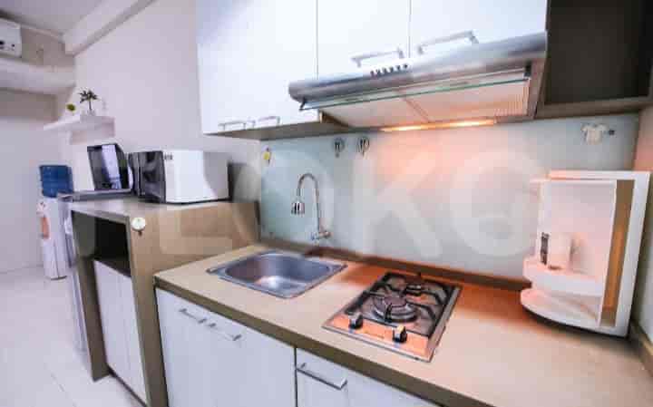 A close-up view of a kitchenette with a gas stove and sink.