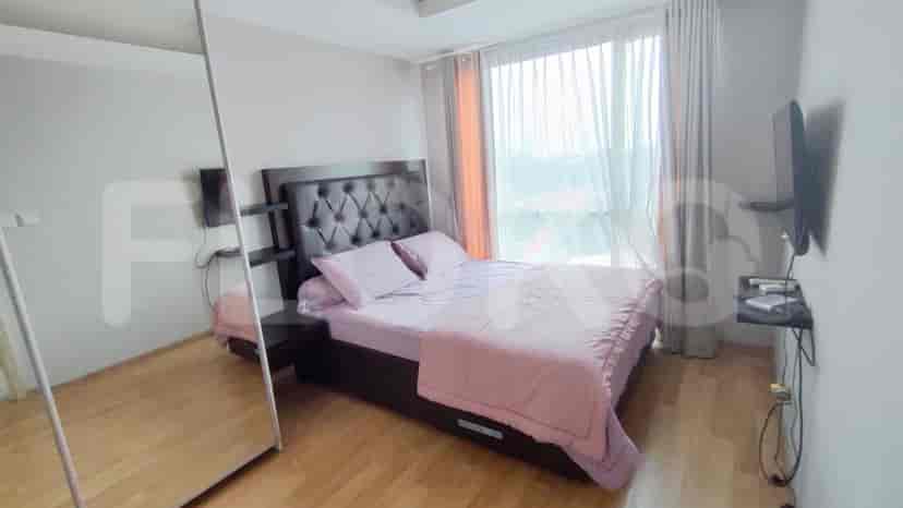A bedroom with a large bed, wooden flooring, and a wardrobe.
