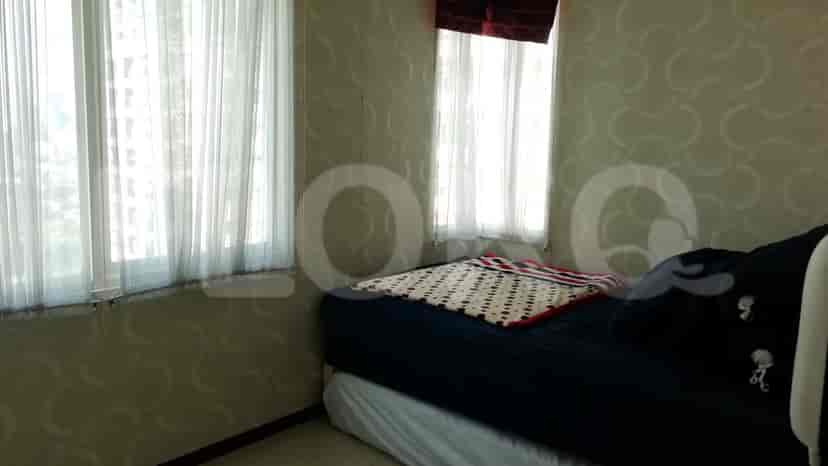 Another bedroom with a bed, window curtains, and wallpapered walls.