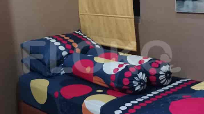 A bedroom with a bed and colorful pillows.