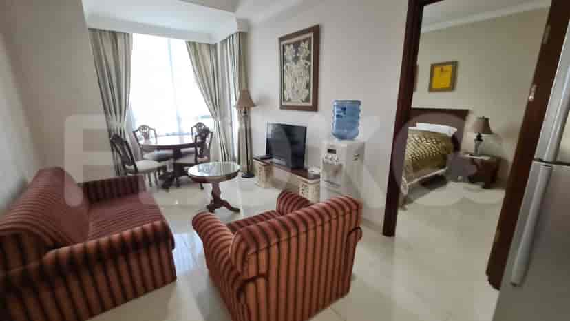 Living area with seating, dining table, TV, and a doorway to the bedroom.