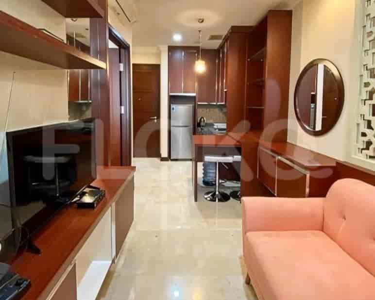Living room featuring a TV and a small kitchen area.