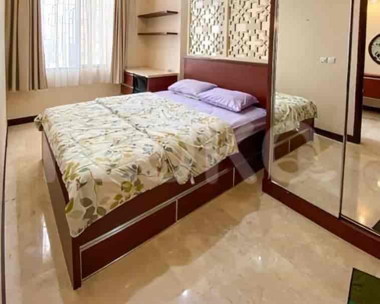 A bedroom with a bed and a mirrored closet.