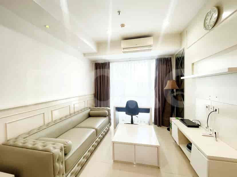 Modern living room with a grey sofa, white table, and desk.