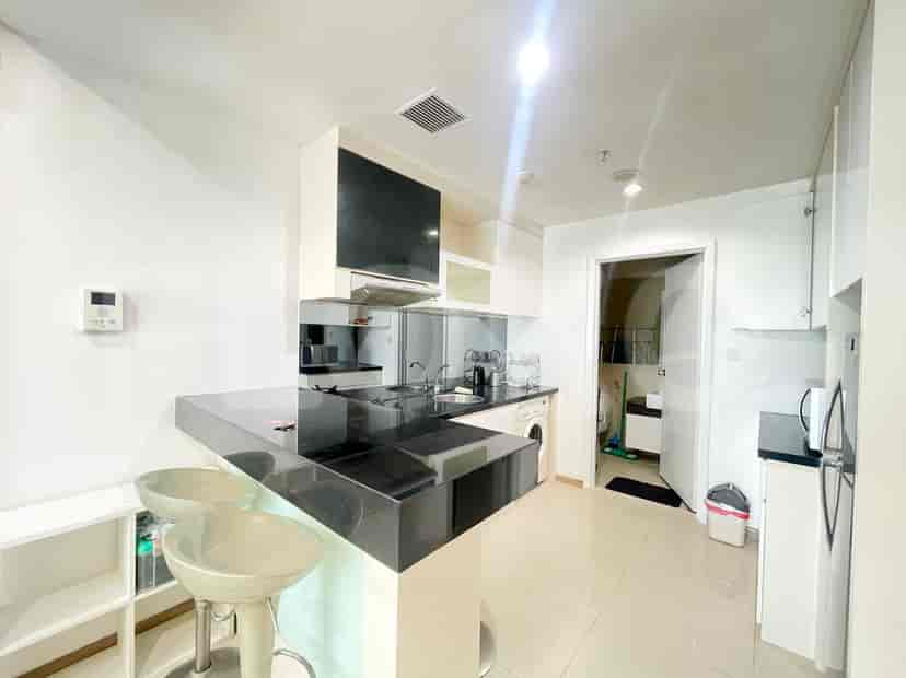 Modern kitchen with dark countertop and white cabinets.