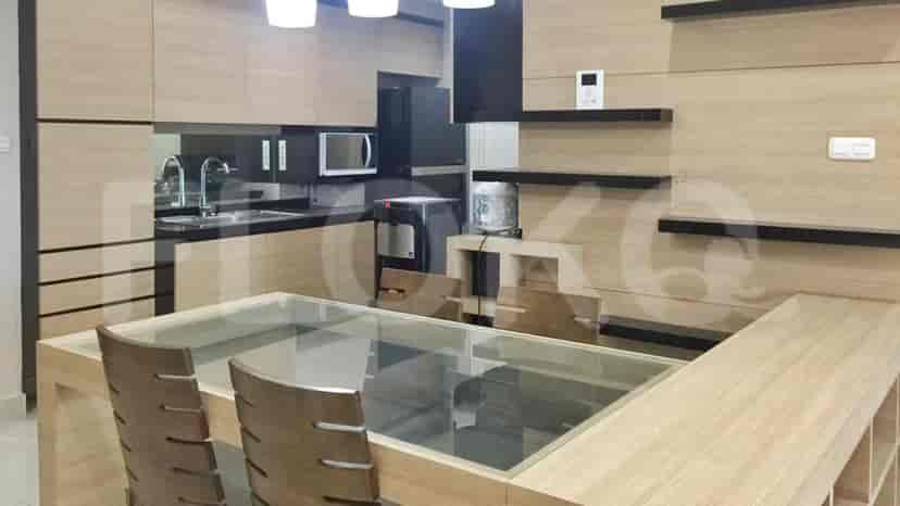 Modern kitchen with wood cabinets, stainless steel appliances, and black countertops.