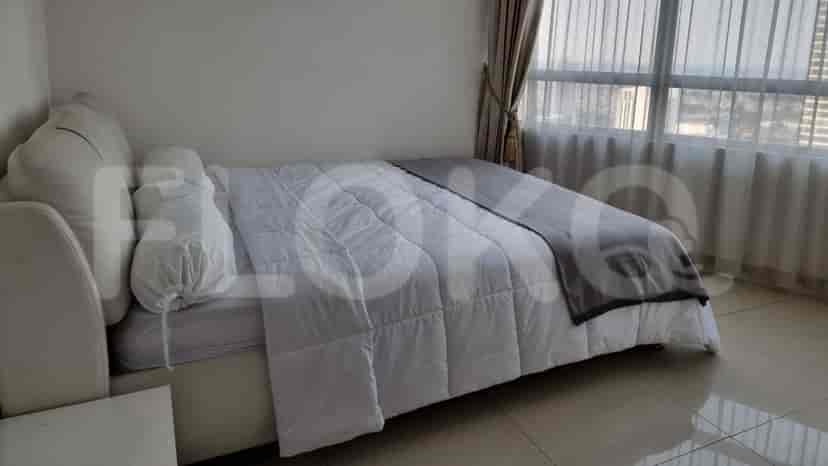 A cozy bedroom with a double bed and a large window.