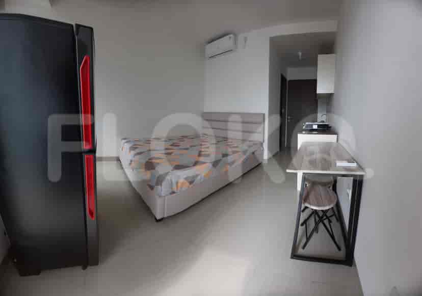 A small studio apartment with a bed, kitchenette, and small dining table.